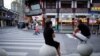 FILE - People rest on stone barricades on a street, following the coronavirus disease (COVID-19) outbreak, in Shanghai, China, Sept. 9, 2022.