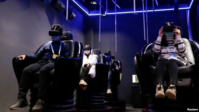 People try virtual reality (VR) goggles during an organised media tour to a demonstration zone of Leyard Photoelectric Group in Beijing, China February 10, 2022. (REUTERS/Florence Lo)