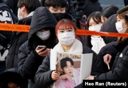 A fan waits for the arrival of Jin, the oldest member of the K-pop band BTS, in Yeoncheon, South Korea December 13, 2022. (REUTERS/Heo Ran)