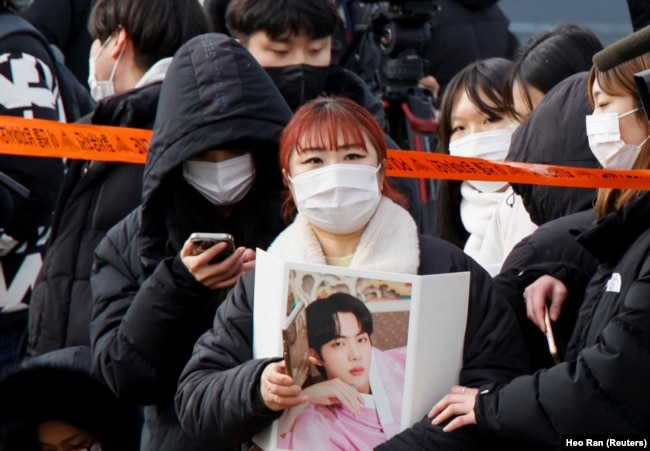 A fan waits for the arrival of Jin, the oldest member of the K-pop band BTS, in Yeoncheon, South Korea December 13, 2022. (REUTERS/Heo Ran)