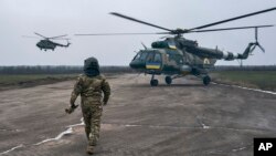 A pilot approaches his helicopter at a Ukrainian military air base close to the front line in Ukraine's Kherson region, Jan. 8, 2023.
