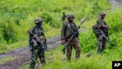 FILE - M23 rebels stand with theirs weapons in the town of Kibumba, in the eastern of Democratic Republic of Congo, Dec. 23, 2022.