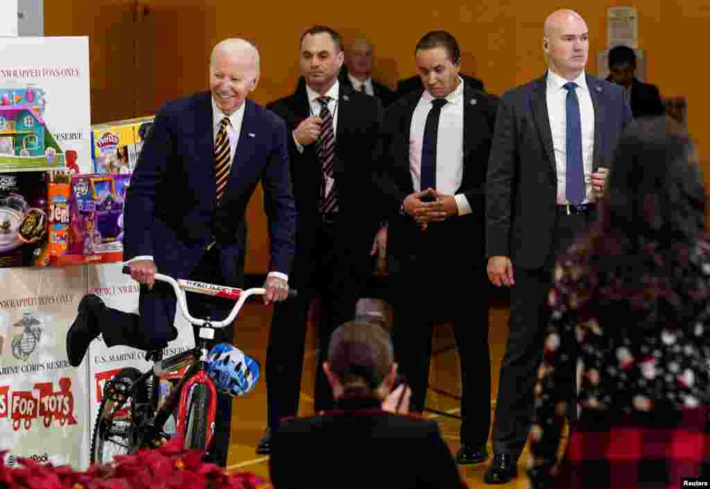 President Biden pretends to ride a bike during the U.S. Marine Corps Reserve Toys for Tots event at Joint Base Myer-Henderson Hall in Arlington, Virginia, Dec. 12, 2022.