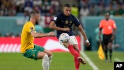 Kylian Mbappé, de Francia, controla el balón junto a Milos Degenek de Australia (izq.) durante el partido de fútbol del grupo D de la Copa Mundial en el estadio Al Janoub en Al Wakrah, Qatar, el martes 22 de noviembre de 2022.