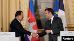 ប្រធានាធិបតីបារាំងលោក Emmanuel Macron និងលោកនាយករដ្ឋមន្ត្រី ហ៊ុន សែន ចាប់ដៃស្វាគមន៍គ្នា ក្នុងអំឡុងសន្និសីទសារព័ត៌មានរួមគ្នាមួយ នៅវិមានរដ្ឋាភិបាលបារាំង Elysee ទីក្រុងប៉ារីស ប្រទេសបារាំង ថ្ងៃទី ១៣ ខែធ្នូ ឆ្នាំ ២០២២។