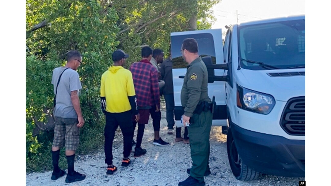 Yon gad fwontye Etazini veye migran kap antre nan yon kamyonet sou riyel Garden Cove nan zile Key Largo, Florid, 3 Janvye 2023.