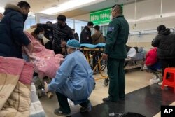 Seorang pasien yang sakit dipindahkan ke brankar di unit gawat darurat Rumah Sakit Rakyat No. 4 Langfang di kota Bazhou di Provinsi Hebei, China utara, pada 22 Desember 2022. (Foto: AP)
