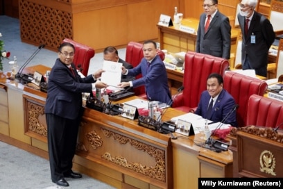 Bambang Wuryanto, Ketua Komisi Pembina RUU DPR, menyerahkan laporan KUHP baru itu kepada Sufmi Dasco Ahmad, Wakil Ketua DPR, dalam rapat paripurna DPR di Jakarta, 6 Desember 2022. (Foto: REUTERS /Willy Kurniawan)