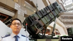 资料照：在台北举行的太空与国防技术展览会上一名台湾军人站在爱国者导弹发射器旁。（2013年8月14日）