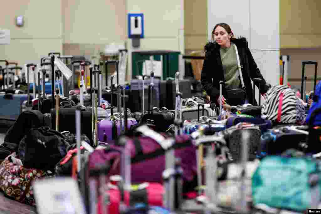 A Southwest Airlines traveler looks for her baggage in a pile of lost suitcases at Chicago Midway International Airport in Chicago, Illinois, Dec. 27, 2022, after an arctic blast and a massive winter storm Elliott swept over much of the United States in the lead-up to the Christmas holiday weekend.