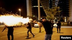 Seorang polisi melepaskan tembakan di tengah demo yang dilakukan oleh para pendukung Jair Bolsonaro di Brasilia, pada 12 Desember 2022. (Foto: Reuters/Ueslei Marcelino)