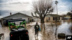 Brenda Ortega, 15, salvages items from her flooded home in Merced, California, on Jan. 10, 2023.