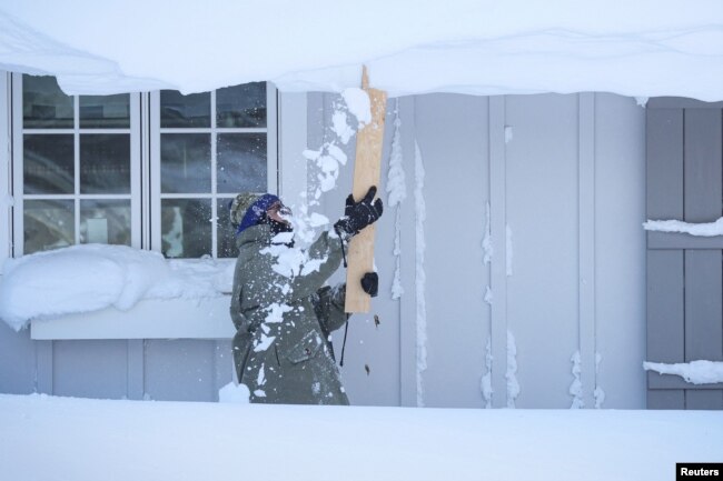 Un hombre limpia la nieve de su techo luego de una tormenta de invierno que azotó la región de Buffalo en Amherst, Nueva York, EEUU, el 25 de diciembre de 2022. REUTERS/Brendan McDermid