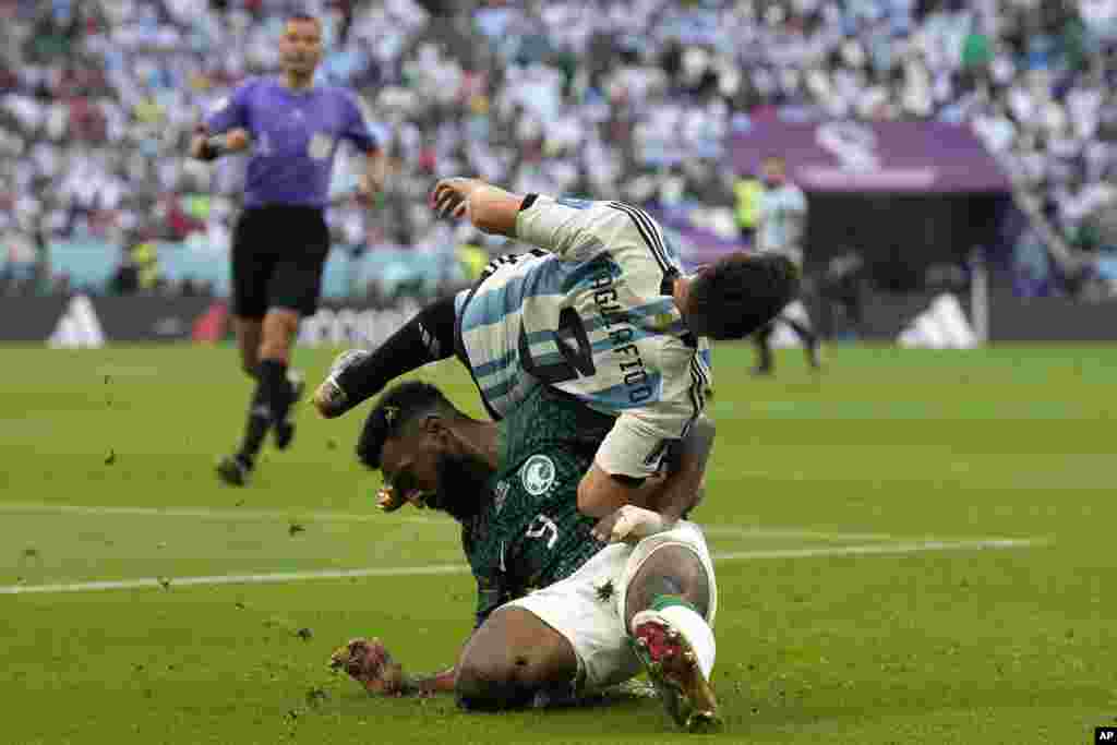 Saudi Arabia&#39;s Firas Al-Buraikan and Argentina&#39;s Nicolas Tagliafico challenge for the ball during the World Cup group C soccer match between Argentina and Saudi Arabia at the Lusail Stadium in Lusail, Qatar.