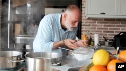 This image provided by Discovery shows host Jose Andres in the kitchen cooking for his family and friends in Asturias in a scene from the Discovery + television series "Jose Andres and Family in Spain." (Discovery via AP)