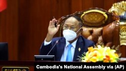 រូបឯកសារ៖ លោក ហេង សំរិន ប្រធាន​សភា​ជាតិ​កម្ពុជា លើកដៃ​ឡើង​ក្នុង​ពេល​លោក​ដឹកនាំ​កិច្ចប្រជុំ​មួយ​នៅ​សភា​ជាតិ​ក្នុង​រាជធានី​ភ្នំពេញ ថ្ងៃទី ២៥ ខែតុលា ឆ្នាំ២០២១។ (Cambodia's National Assembly via AP)