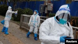 Pandemic prevention workers in protective suits walk outside a locked-down residential compound as COVID-19 outbreaks continue in Beijing, China, Nov. 18, 2022. 