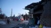 La gente pasa frente a una parte dañada de una casa después de lo que funcionarios rusos en Donetsk dijeron que fue un bombardeo de las fuerzas ucranianas, en Donetsk, en la región de Donetsk controlada por Rusia, en el este de Ucrania, el martes 10 de enero de 2023. (Foto AP)