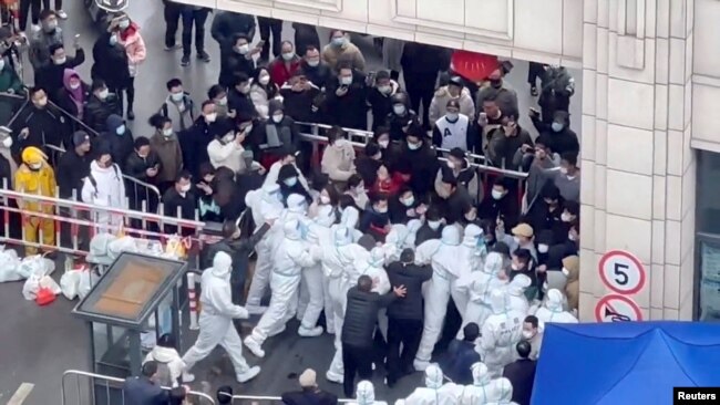 FILE - Residents confront workers donned in protective suits who are blocking the entrance of a residential compound, amid the coronavirus disease (COVID-19) outbreak in Shanghai, China, in this still image obtained from a social media video released November 30, 2022. (Video obtained by Reuters/via REUTERS)