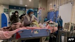 天津第一中心医院的医护人员在护理一名感染新冠的病人。（2022年12月28日）