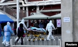 Medical staff moves a patient into a fever clinic at Chaoyang Hospital in Beijing, China, Dec. 13, 2022, in this screen grab taken from a Reuters TV video.
