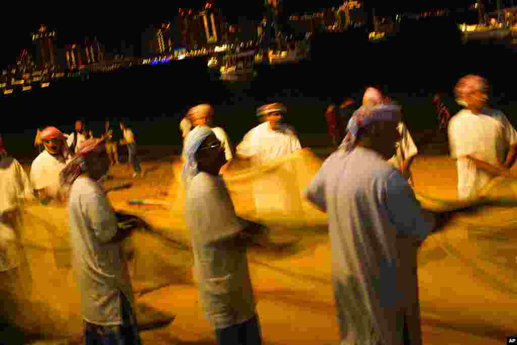 Pescadores realizan una recolección tradicional de una red de pesca para una televisión local en la playa de Katara en Doha, Qatar.