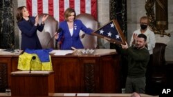 Ukrajinski predsednik Volodimir Zelenski prima američku zastavu koju mu je poklonila Nensi Pelosi, posle govora pred oba doma Kongresa na Kapitol Hilu u Vašingtonu, 21. decembar 2022. (Foto: AP/Carolyn Kaster)