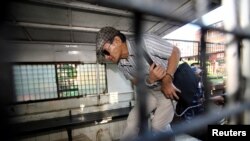 FILE - Serial killer Charles Sobhraj leaves Kathmandu district court after a hearing, in Kathmandu, Nepal, May 31, 2011.