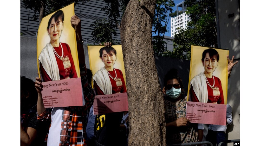 Pengunjuk rasa Burma membawa foto pemimpin sipil Myanmar Aung San Suu Kyi yang ditahan dalam aksi unjuk rasa di luar Kedutaan Besar Myanmar di Bangkok,19 Desember 2022. (Jack TAYLOR / AFP)