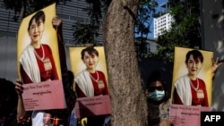 Protesters hold up pictures of detained Myanmar civilian leader Aung San Suu Kyi during a demonstration outside the Embassy of Myanmar in Bangkok on Dec. 19, 2022.