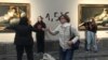 FILE - This handout picture released by Extinction Rebellion environmental movement on Nov. 5, 2022, shows two activists glued by their hands to the frames of two paintings by Spanish master Francisco Goya at the Prado museum in Madrid.