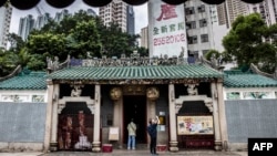 A man takes a photo outside a temple in Ap Lei Chau in Hong Kong on Nov. 21, 2022.