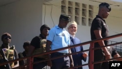 FILE - Former Comorian President Ahmed Abdallah Sambi, escorted by Gendarmes, arrives at the courthouse in Moroni, Nov. 21, 2022. Sambi, who served as president from 2006-2011, has been held under house arrest since May 2018.