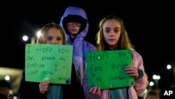 Willow Crawford, left, her sister Ava, right, and friend Kaylynn Vestre show support for Richneck Elementary School teacher Abby Zwerner during a vigil in Newport News, Va., Jan. 9, 2023. Zwerner was shot and wounded by a 6-year-old student Jan. 6.