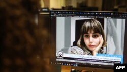 FILE - A woman looks at a computer screen showing undated video of Iranian journalist Nazila Maroufian, in Nicosia, Cyprus, Nov. 4, 2022.