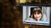 FILE - A woman in the Cypriot capital of Nicosia looks at a screen with an image of Iranian journalist Nazila Maroufian, Nov. 4, 2022. 