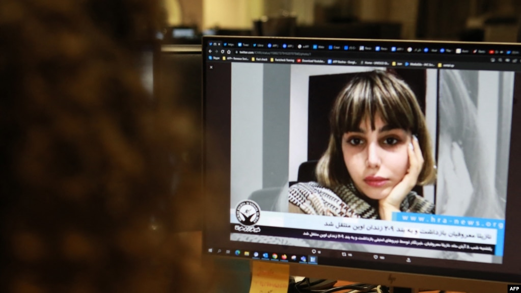 FILE - A woman in the Cypriot capital of Nicosia looks at a screen with an image of Iranian journalist Nazila Maroufian, Nov. 4, 2022. 