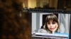 FILE - A woman looks at a screen image of Nazila Maroufian, detained in Iran for coverage of protests, Nov. 4, 2022. 