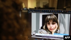 FILE - A woman looks at a screen image of Nazila Maroufian, who is among the dozens of journalists detained in Iran for coverage of protests, Nov. 4, 2022. Iran is the worst jailer of journalists, a new report finds. 