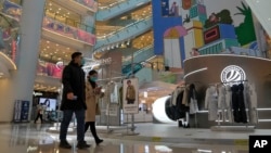 Para pembeli berjalan-jalan di pusat perbelanjaan yang dibuka kembali setelah pihak berwenang mulai melonggarkan beberapa pembatasan COVID-19 di Beijing, 6 Desember 2022. (Foto: AP)