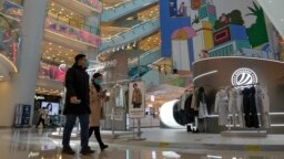 Los compradores caminan por un centro comercial reabierto después de que las autoridades comenzaran a aliviar algunas de las restricciones de COVID-19 en Beijing, el 6 de diciembre de 2022.