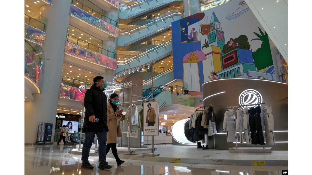 Para pembeli berjalan-jalan di pusat perbelanjaan yang dibuka kembali setelah pihak berwenang mulai melonggarkan beberapa pembatasan COVID-19 di Beijing, 6 Desember 2022. (Foto: AP)