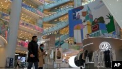 Shoppers walk through a reopened shopping mall after authorities started easing some of the COVID-19 restrictions in Beijing, Dec. 6, 2022.