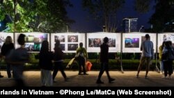Người dân Hà Nội xem những tấm ảnh đoạt giải được trưng bày trên phố đi bộ quanh hồ Hoàn Kiếm tại triển lãm ảnh báo chí thế giới 2021. Triển lãm năm nay bị chính quyền hủy bỏ ngay trước giờ khai mạc hôm 9/12.