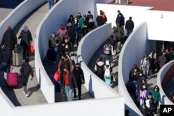 FILE - Migrants seeking asylum enter the U.S. in Tijuana, Mexico, Dec. 21, 2022. (AP Photo/Marcio Jose Sanchez)