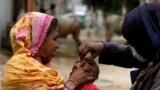FILE - A boy receives polio vaccine drops, during an anti-polio campaign, in a low-income neighborhood, in Karachi, Pakistan July 20, 2020. 