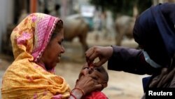 FILE - A boy receives polio vaccine drops, during an anti-polio campaign, in a low-income neighborhood, in Karachi, Pakistan July 20, 2020. 