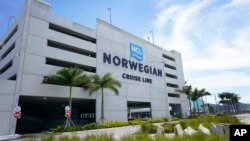 FILE - A sign for the new Norwegian Cruise Line terminal is shown, April 7, 2021, in Miami. 