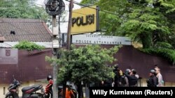 Officers collect evidence following an extremist-motivated suicide bombing attack at a district police station in Indonesia.