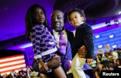 Senator Raphael Warnock (D-GA) holds his daughter Chloe and his son Caleb in his arms during an election night party in Atlanta, Georgia, Dec. 6, 2022. (REUTERS/Carlos Barria)